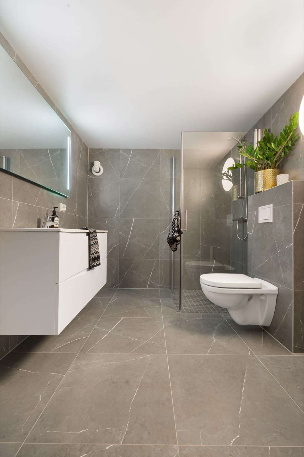Complete badkamerrenovatie met marmerlook tegels en zwevend wastafelmeubel