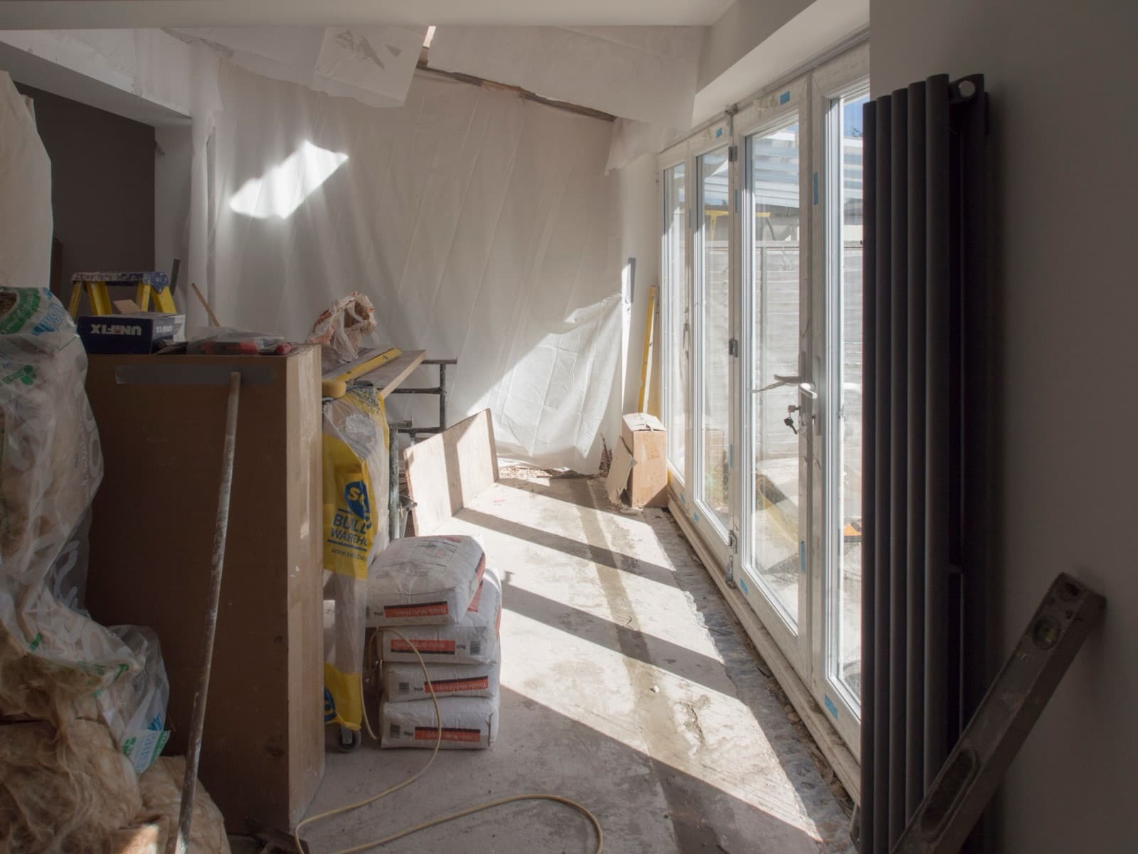 Binnenafwerking van een aanbouw met vouwdeuren en nieuwe radiator