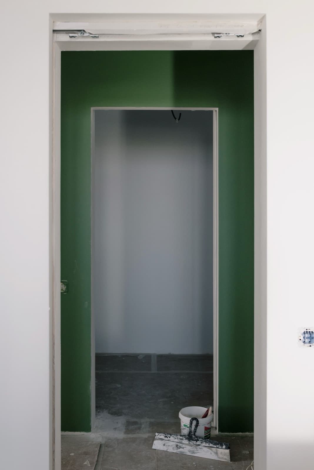 Groen geschilderde wand als kleuraccent rond een deuropening